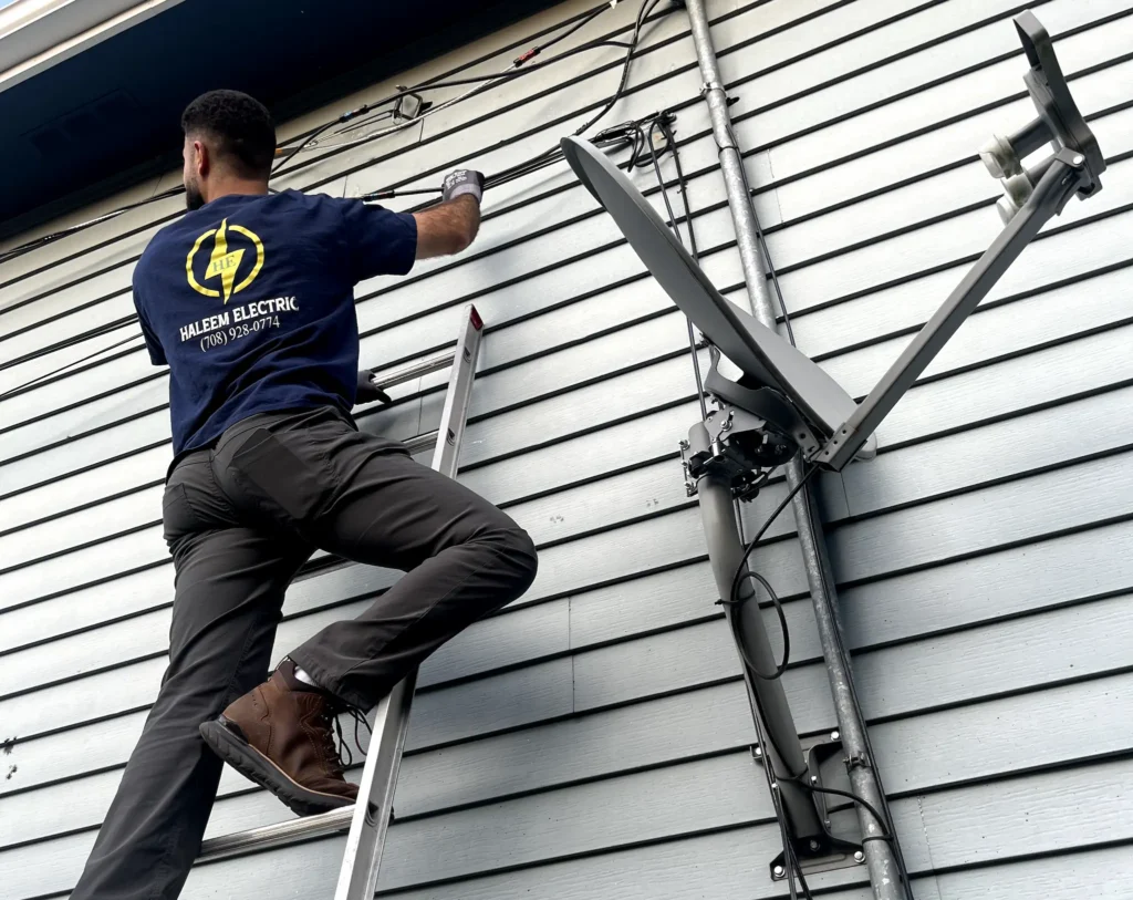 Haleem Electric electrician on a ladder during an installation.