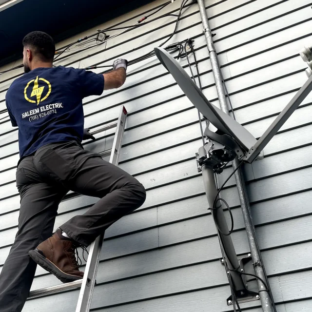 Haleem Electric electrician on a ladder during an installation.